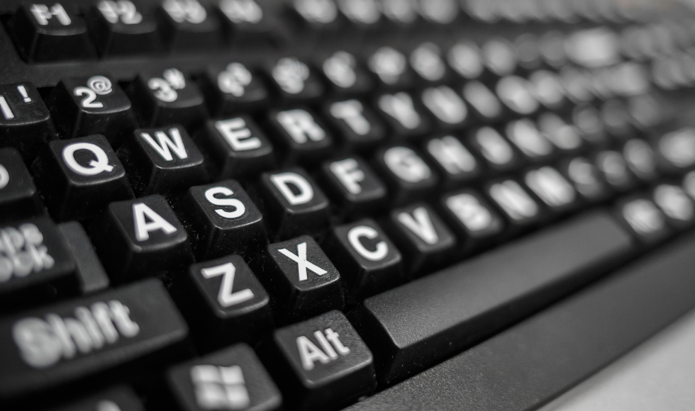 A sideways view of various blurred out keys with letters on them on a keyboard.